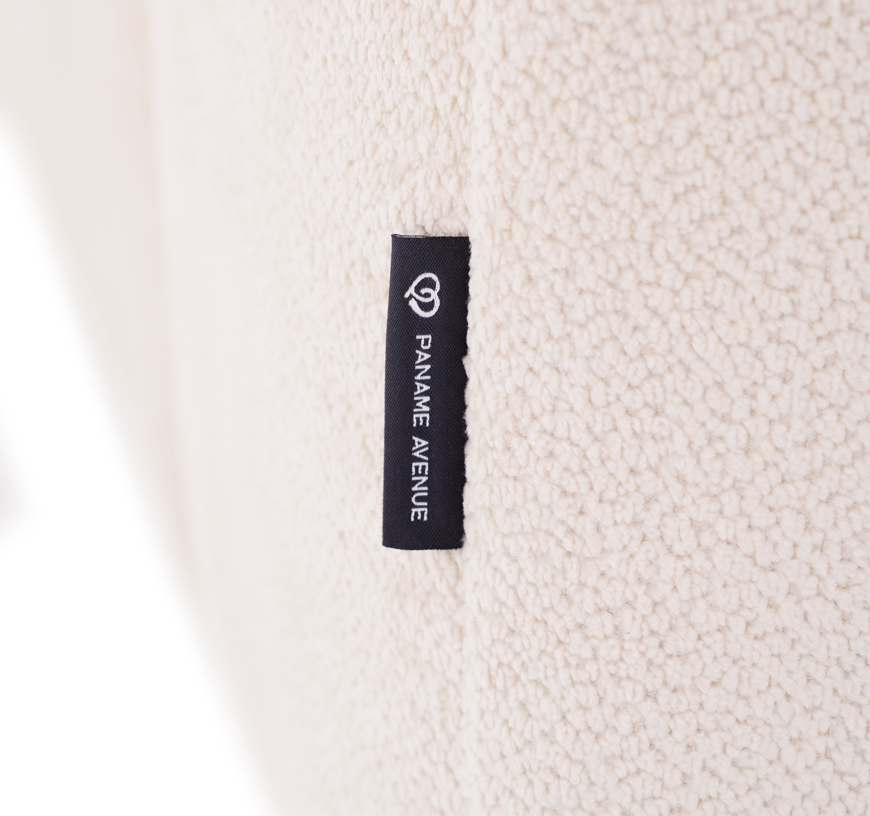 Canapé d’angle gauche Temple en tissu chenille crème Paname Avenue, détail du label de la marque