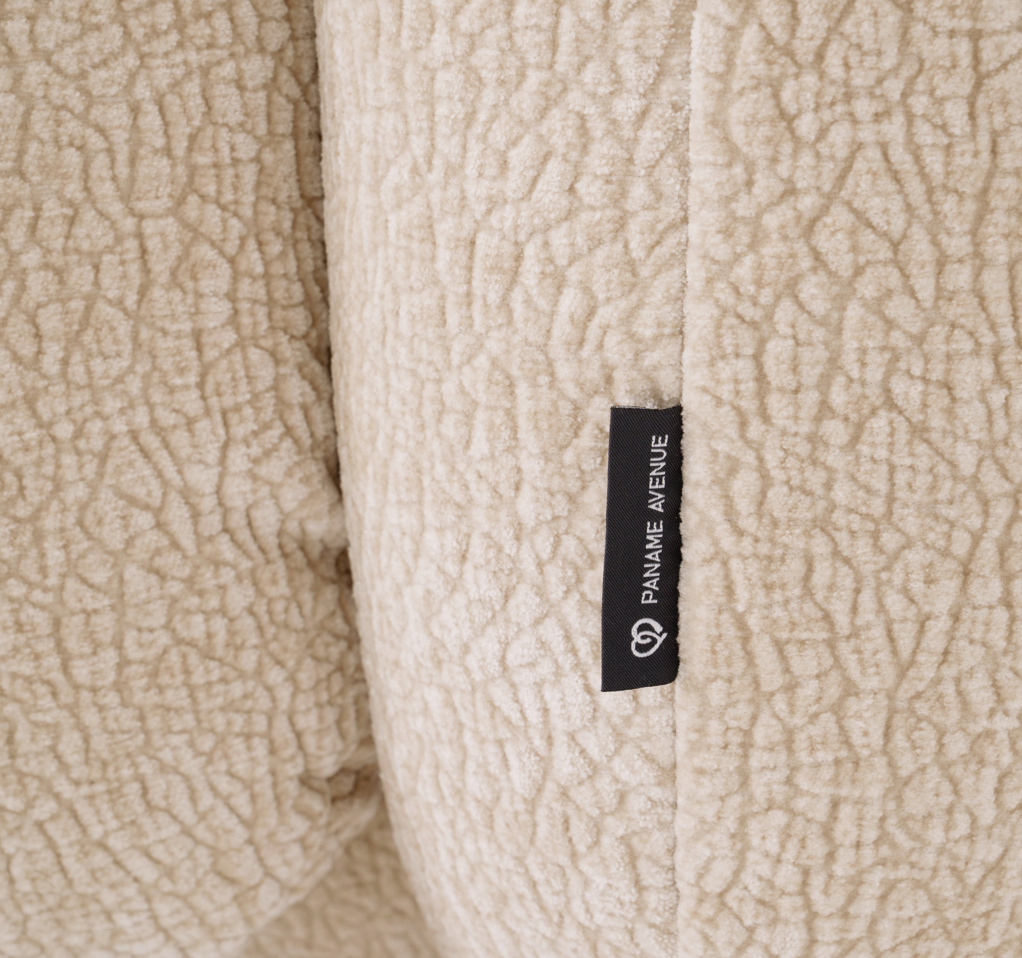 Fauteuil Fontaine en tissu chenille beige Paname Avenue, détail du label de la marque
