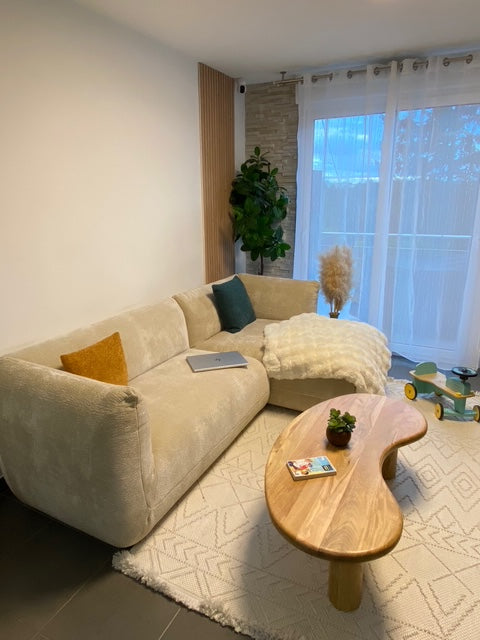 Canapé d'angle Sainte-Croix beige avec méridienne Paname Avenue et table basse en bois dans un salon contemporain aux tons naturels - retour client