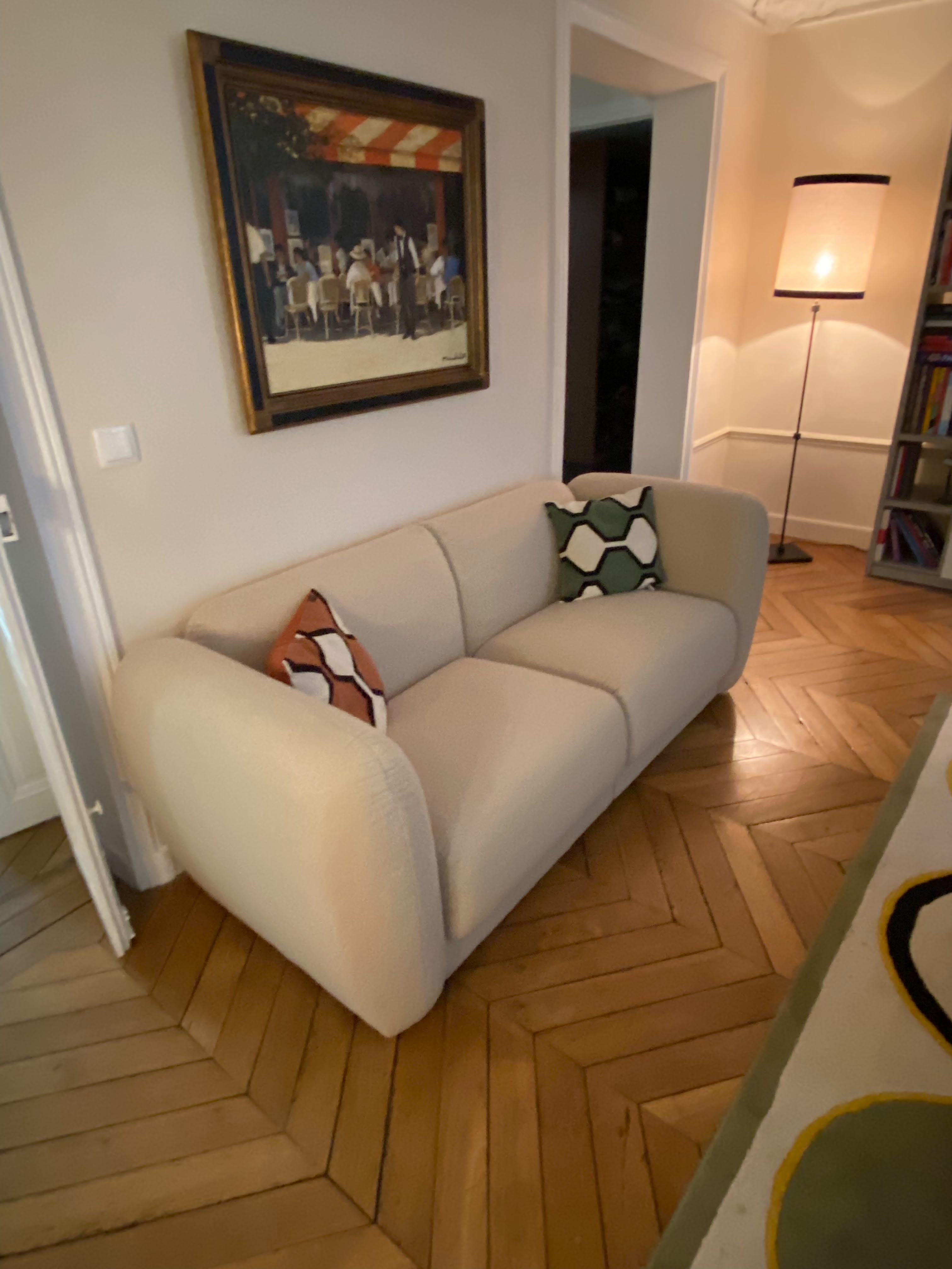 Canapé droit Pigalle en tissu bouclette beige Paname Avenue - vue de 3/4 mettant en valeur l'assise généreuse et le revêtement bouclette  dans un salon haussmannien - retour client