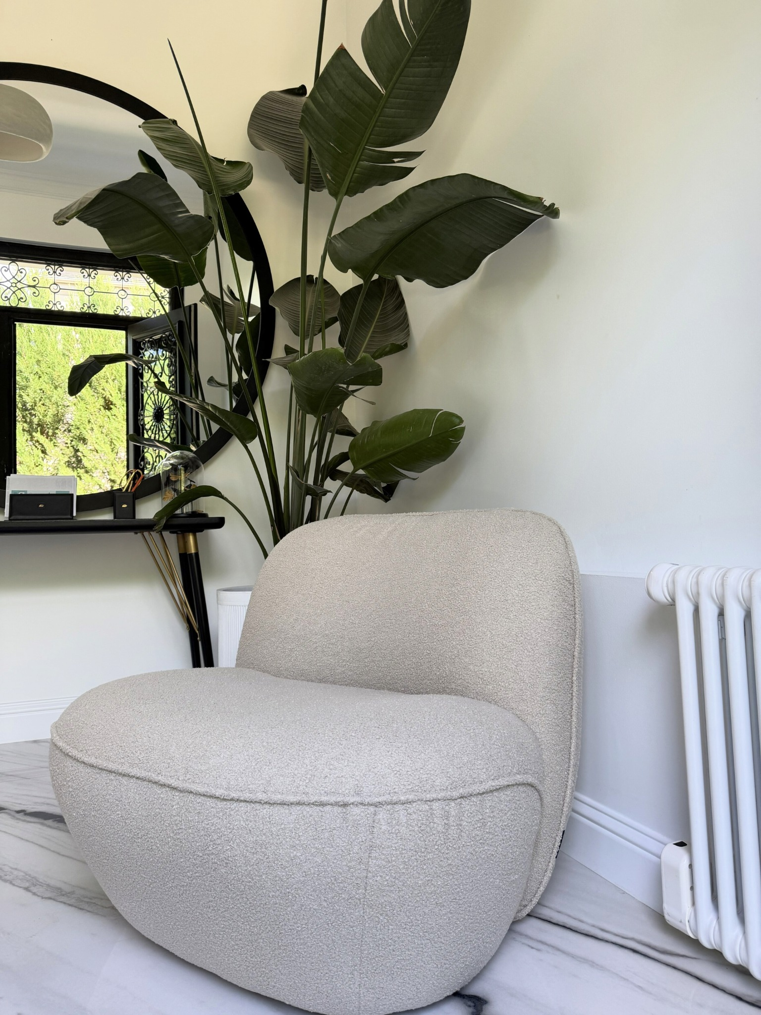 Fauteuil Fontaine en tissu bouclette beige Paname Avenue dans une décoration contemporaine avec miroir design et plante tropicale - retour client