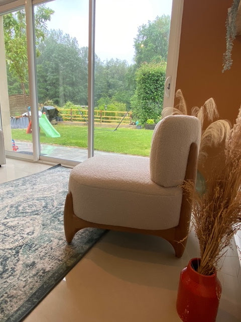 Fauteuil Rivoli en tissu bouclette beige Paname Avenue près d'une baie vitrée avec vue sur le jardin - retour client
