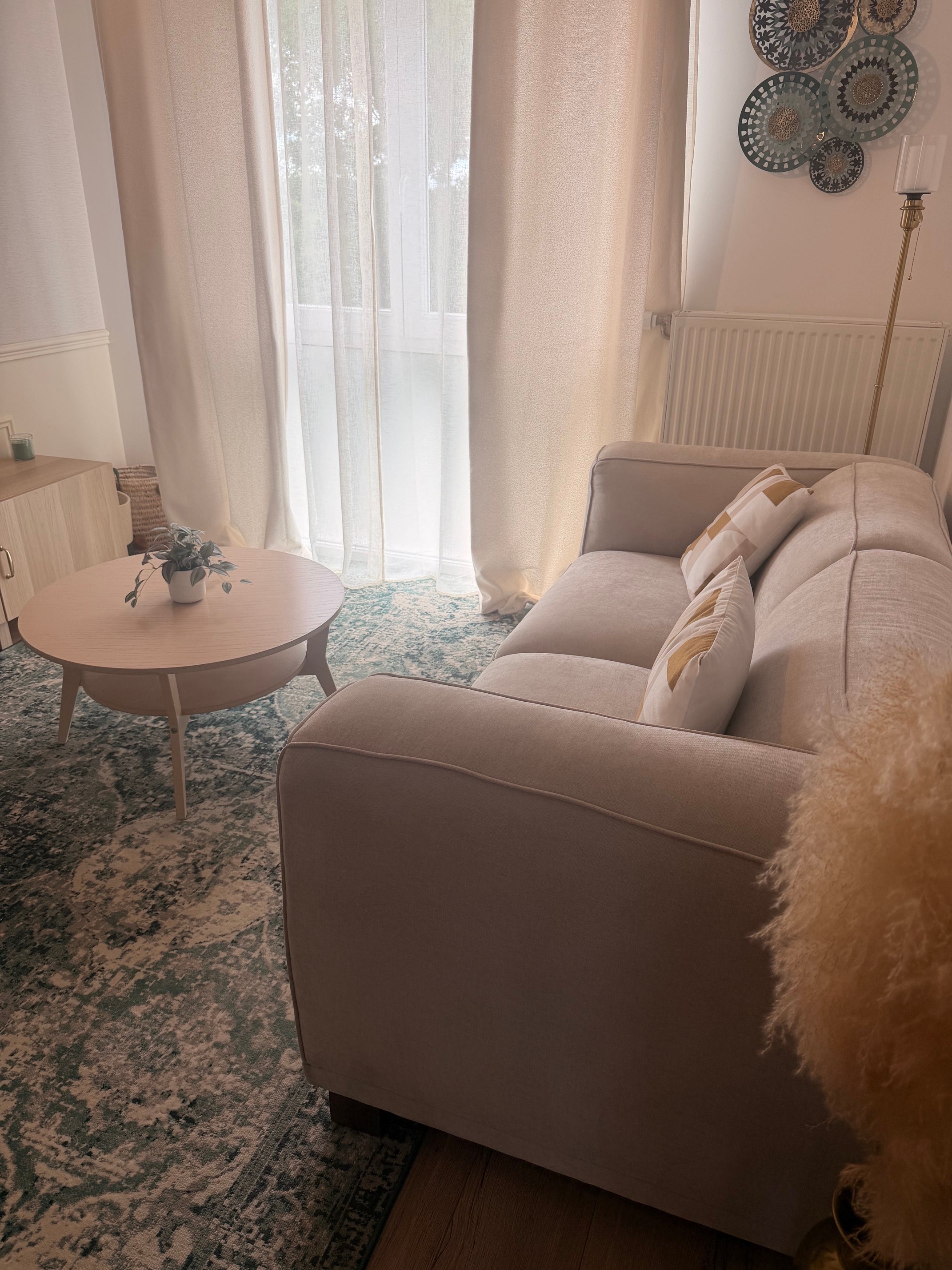 Canapé droit Poulbot en tissu chenille beige Paname Avenue vu de profil dans un salon lumineux avec table basse ronde - retour client