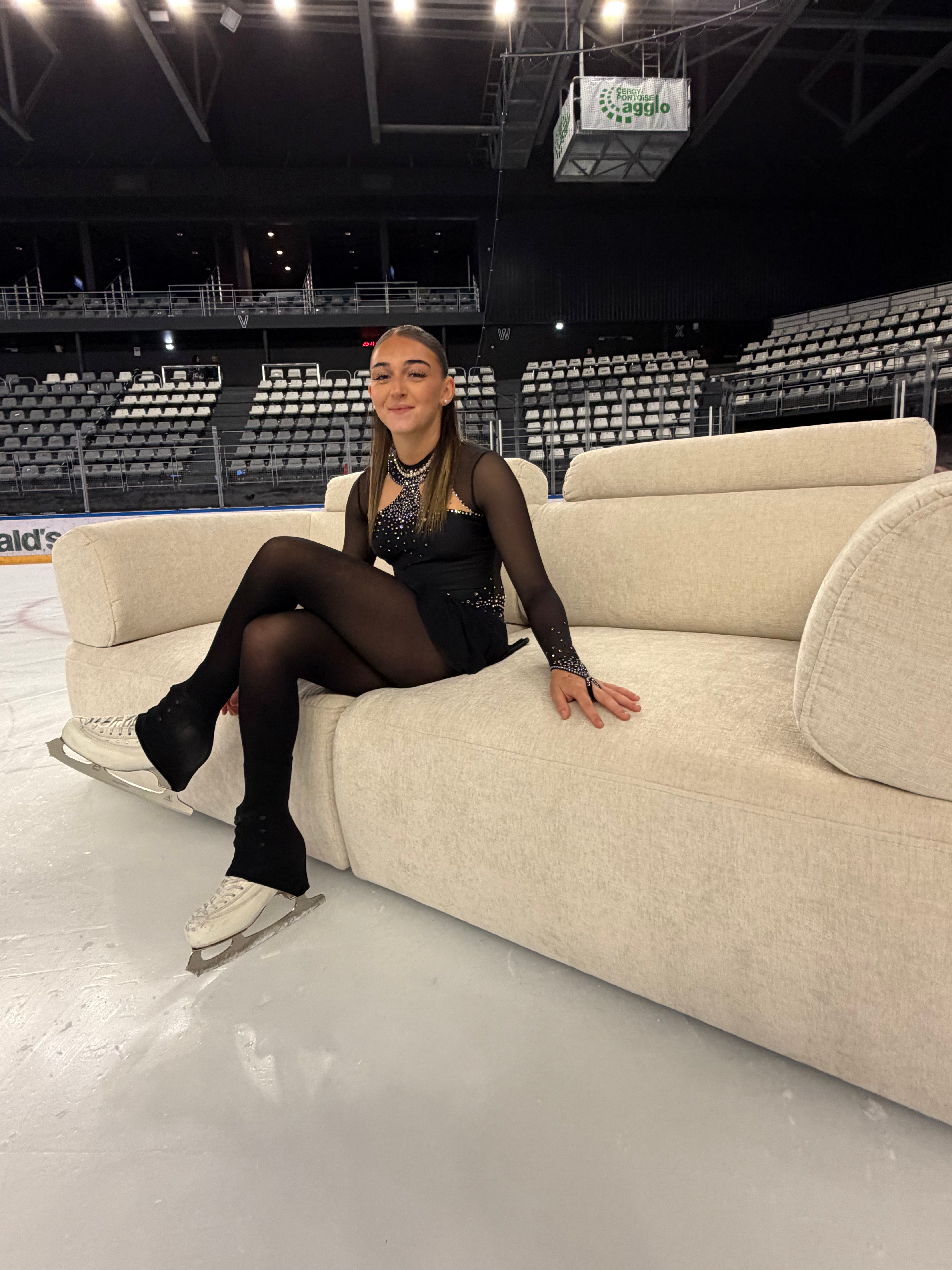 Canapé droit 3 places Réaumur en tissu chenille beige apaisé de chez Paname Avenue en vue 3/4 dans une patinoire pour le tournage d'une campagne marketing de la marque avec une patineuse professionnelle.
