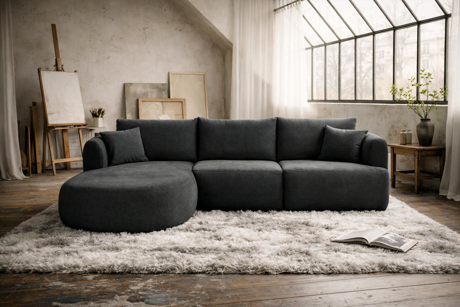 Canapé d’angle gauche Lepic Paname Avenue en tissu chenille anthracite avec méridienne dans un salon lumineux style atelier avec grande verrière, tapis épais et ambiance contemporaine chaleureuse