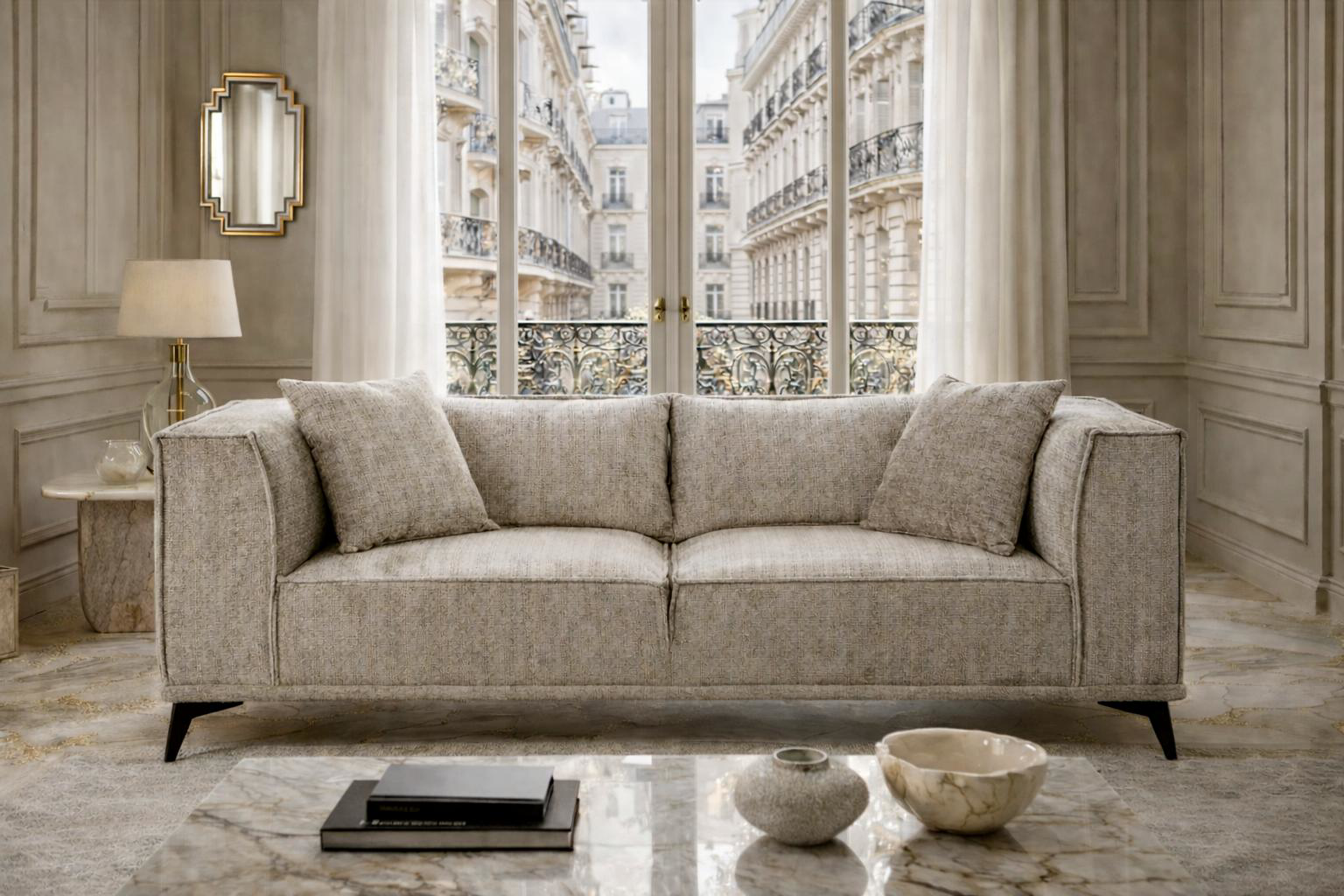 Canapé droit Abbesses Paname Avenue dans un salon haussmannien lumineux, devant une grande fenêtre avec balcon parisien en fer forgé, table basse en marbre et décoration élégante.