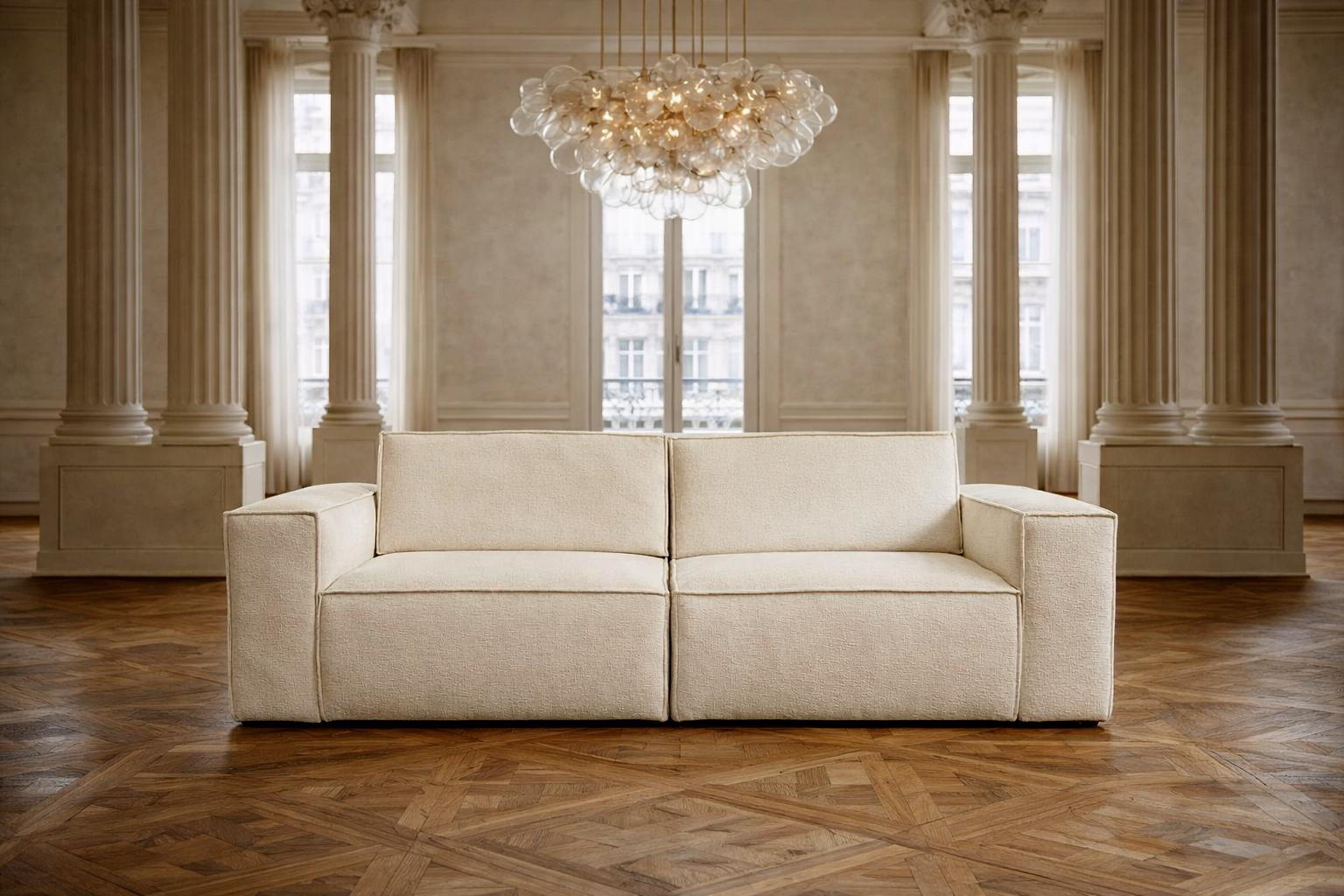 Canapé droit Beaux-Arts en tissu chenille beige de Paname Avenue installé dans un luxueux salon haussmannien avec un lustre monumental 