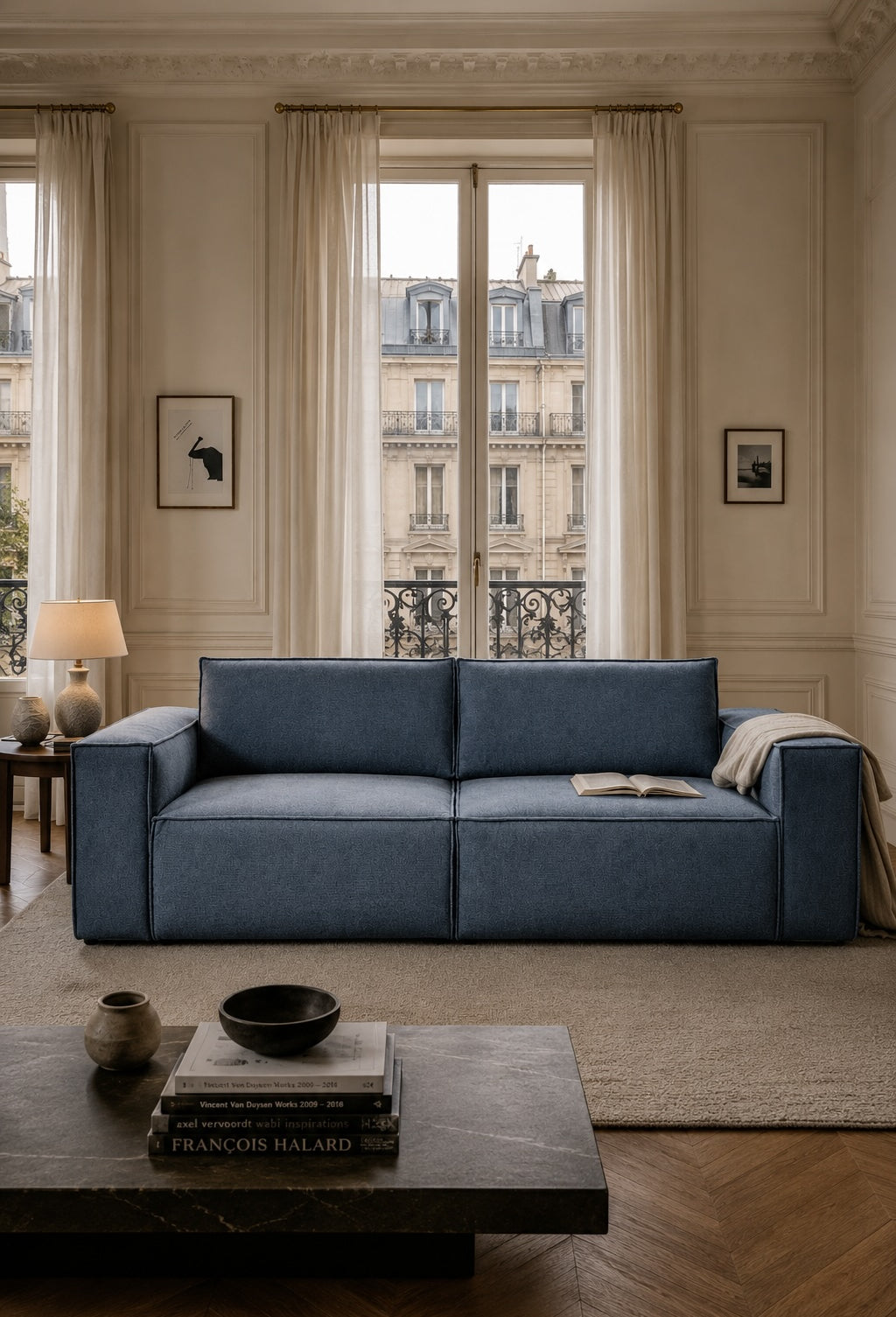 Canapé droit Beaux-Arts en tissu chenille bleu avec table basse effet pierre dans un salon haussmannien élégant aux influences contemporaines