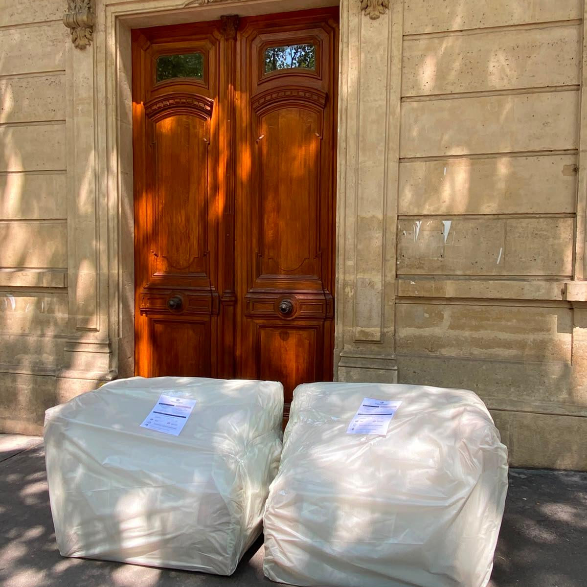 Photo d'un canapé Pigalle Paname Avenue  livré en deux colis devant la porte d'une cliente, au pied de son immeuble.
