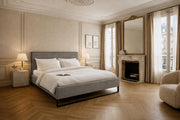 Lit Debelleyme en tissu chenille taupe de chez Paname Avenue dans une chambre parisienne avec cheminée en marbre et parquet en point de Hongrie
