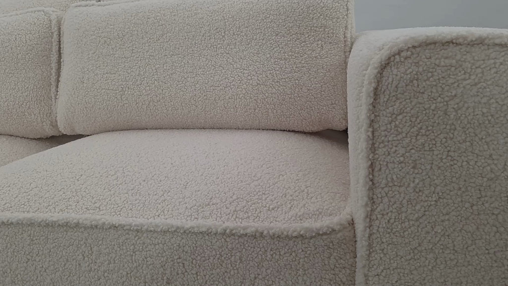 Vidéo de présentation du canapé droit Descartes en tissu bouclette beige, filmé en studio photo. Cette démonstration met en avant le design, les proportions, les accoudoirs et la qualité du revêtement.