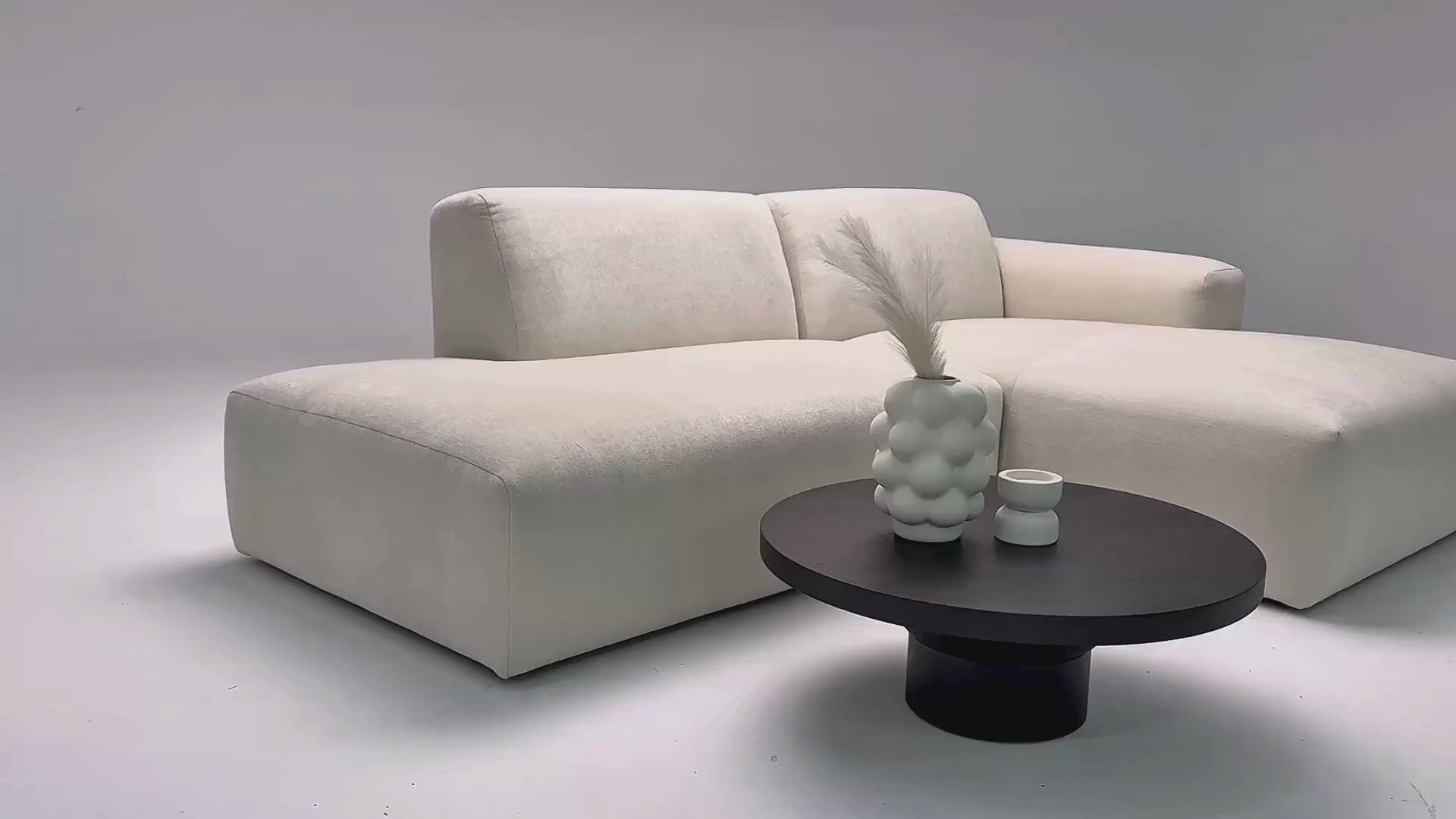 Vidéo de présentation du canapé d'angle Archives en tissu chenille beige, filmé en studio photo. Cette démonstration met en avant le design, les proportions, les accoudoirs et la qualité du revêtement.
