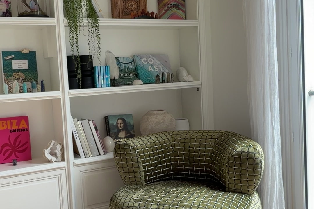 Cliente prenant le thé dans son salon, assise sur le fauteuil Montorgueil en velours lisse vert olive de Paname Avenue.