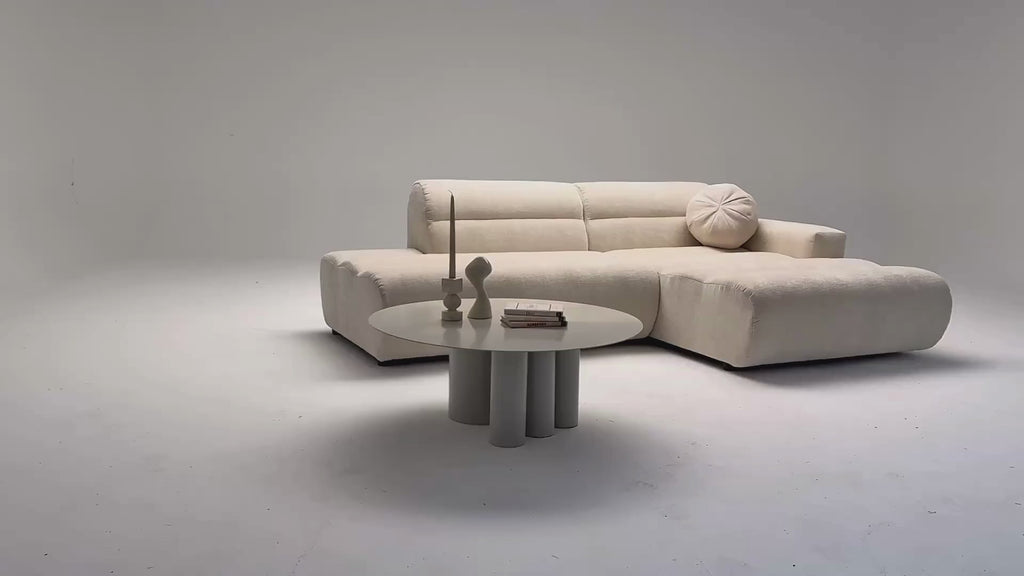 Vidéo de présentation du canapé d'angle Notre-Dame-de-Nazareth en tissu chenille beige, filmé en studio photo. Cette démonstration met en avant le design, les proportions, les accoudoirs et la qualité du revêtement.