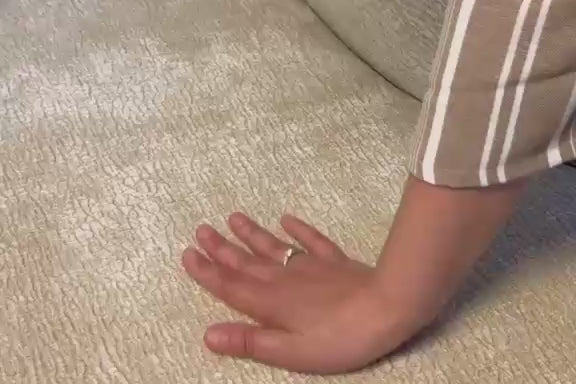 Vidéo d'une cliente filmant le tissu chenille beige du canapé Sainte-Croix en montrant le rembourrage des accoudoirs et la douceur du revêtement. 