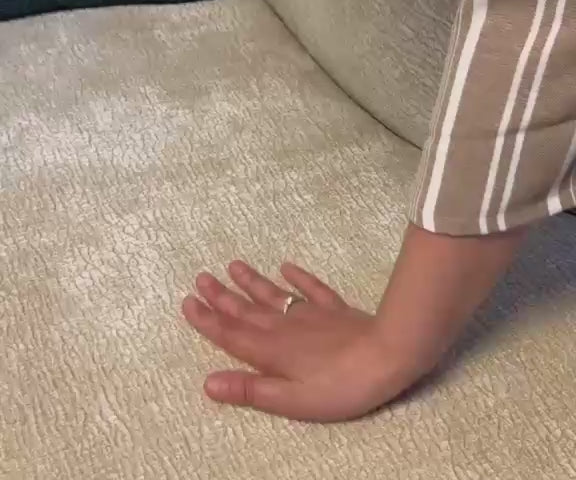 Vidéo d'une cliente filmant le tissu chenille beige du canapé Sainte-Croix en montrant le rembourrage des accoudoirs et la douceur du revêtement. 