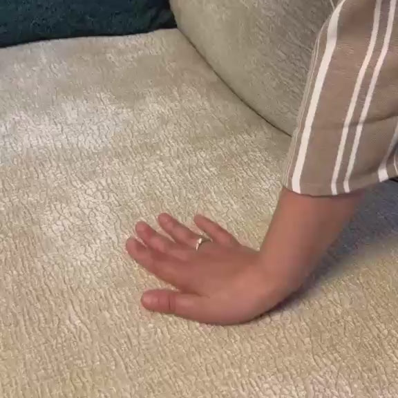 Vidéo d'une cliente filmant le tissu chenille beige du canapé Sainte-Croix en montrant le rembourrage des accoudoirs et la douceur du revêtement. 