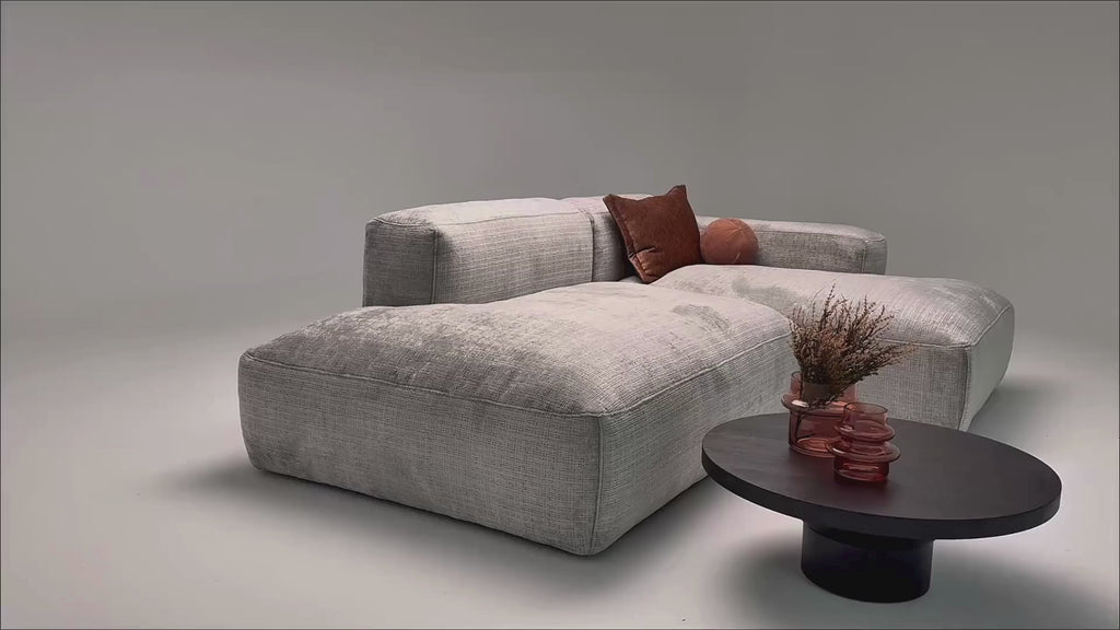 Vidéo de présentation du canapé d'angle Marché-Saint-Honoré en tissu chenille gris clair, filmé en studio photo. Cette démonstration met en avant le design, les proportions, les accoudoirs et la qualité du revêtement.