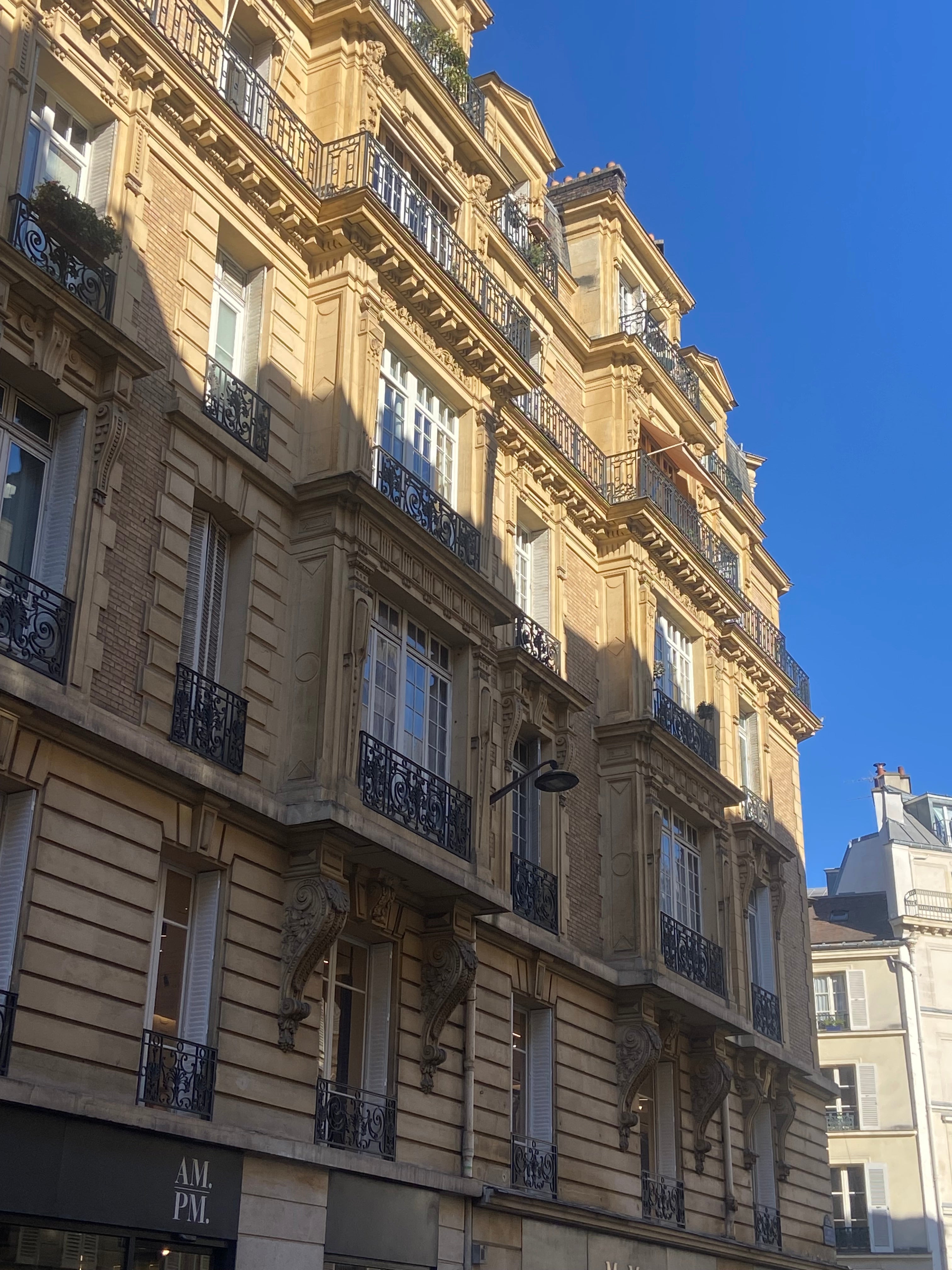 Immeuble haussmannien rue Bonaparte à Saint-Germain-des-Prés Paris 6 avec façades élégantes, balcons en fer forgé et lumière dorée sur pierre parisienne