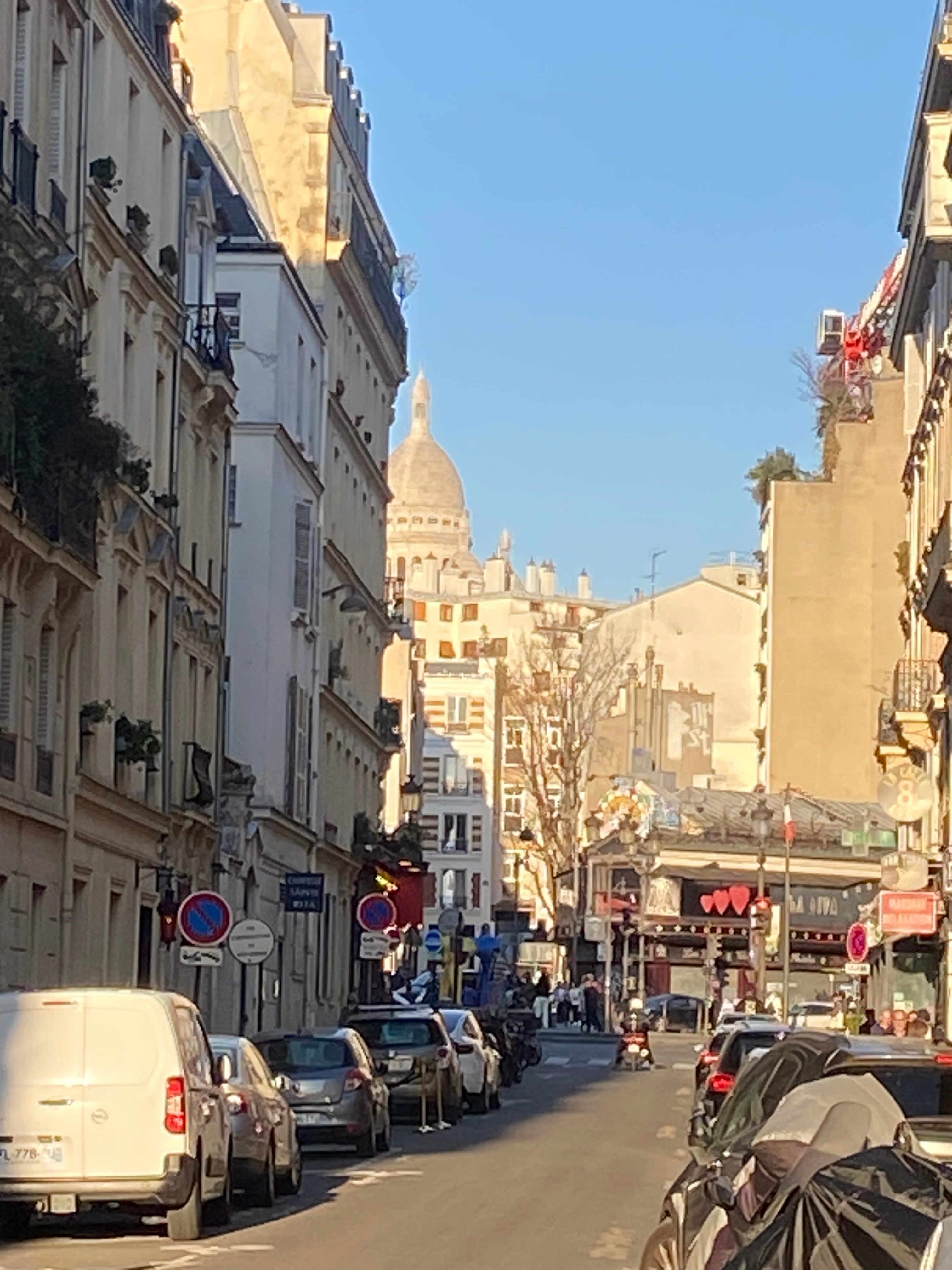 Rue de Bruxelles à Pigalle Paris 9 avec vue sur le Sacré-Cœur, immeubles parisiens et ambiance urbaine animée
