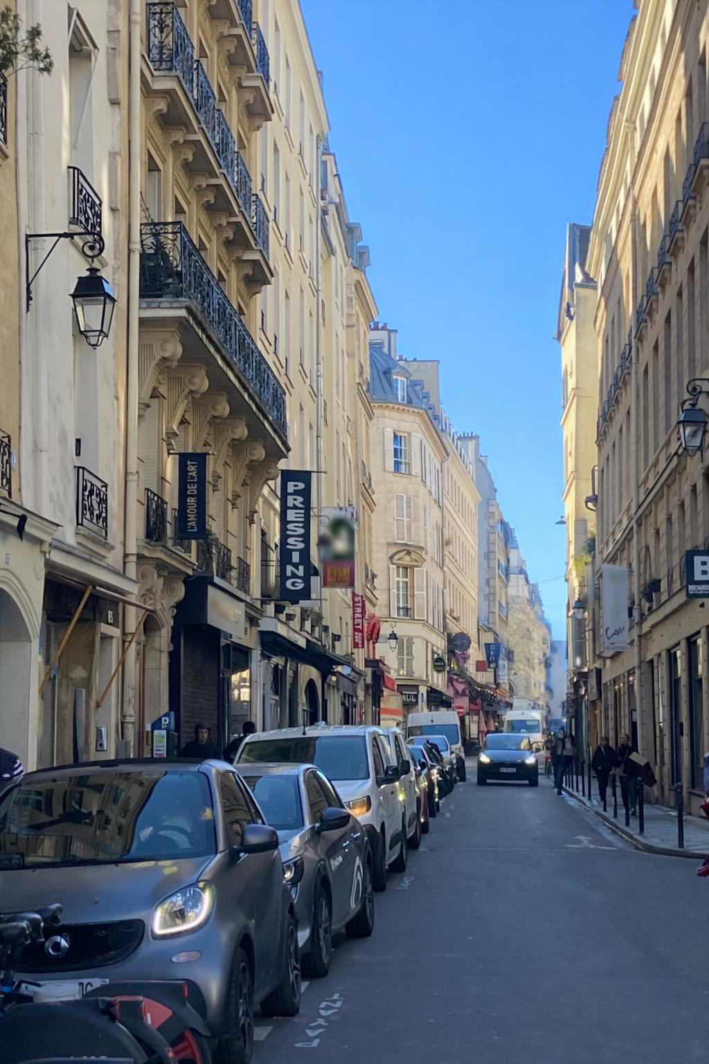 Rue de Seine Paris 6 avec commerces, voitures stationnées et architecture haussmannienne typique de Saint-Germain-des-Prés