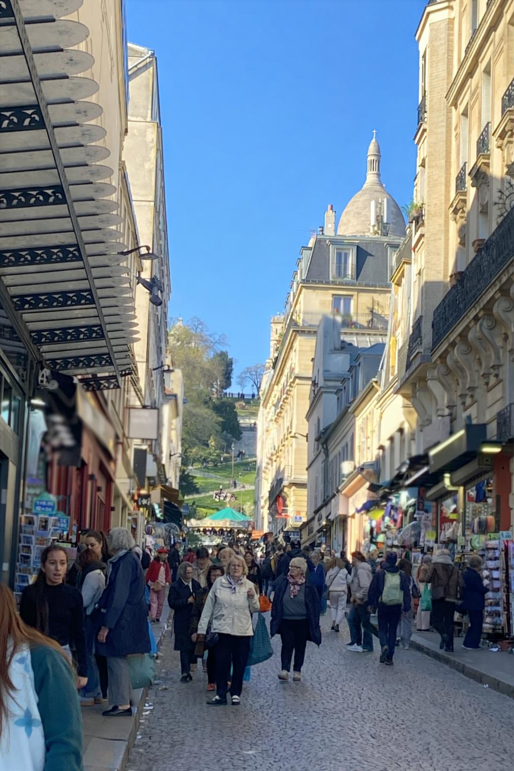 Rue de Steinkerque à Montmartre Paris avec foule de touristes et vue vers le Sacré-Cœur