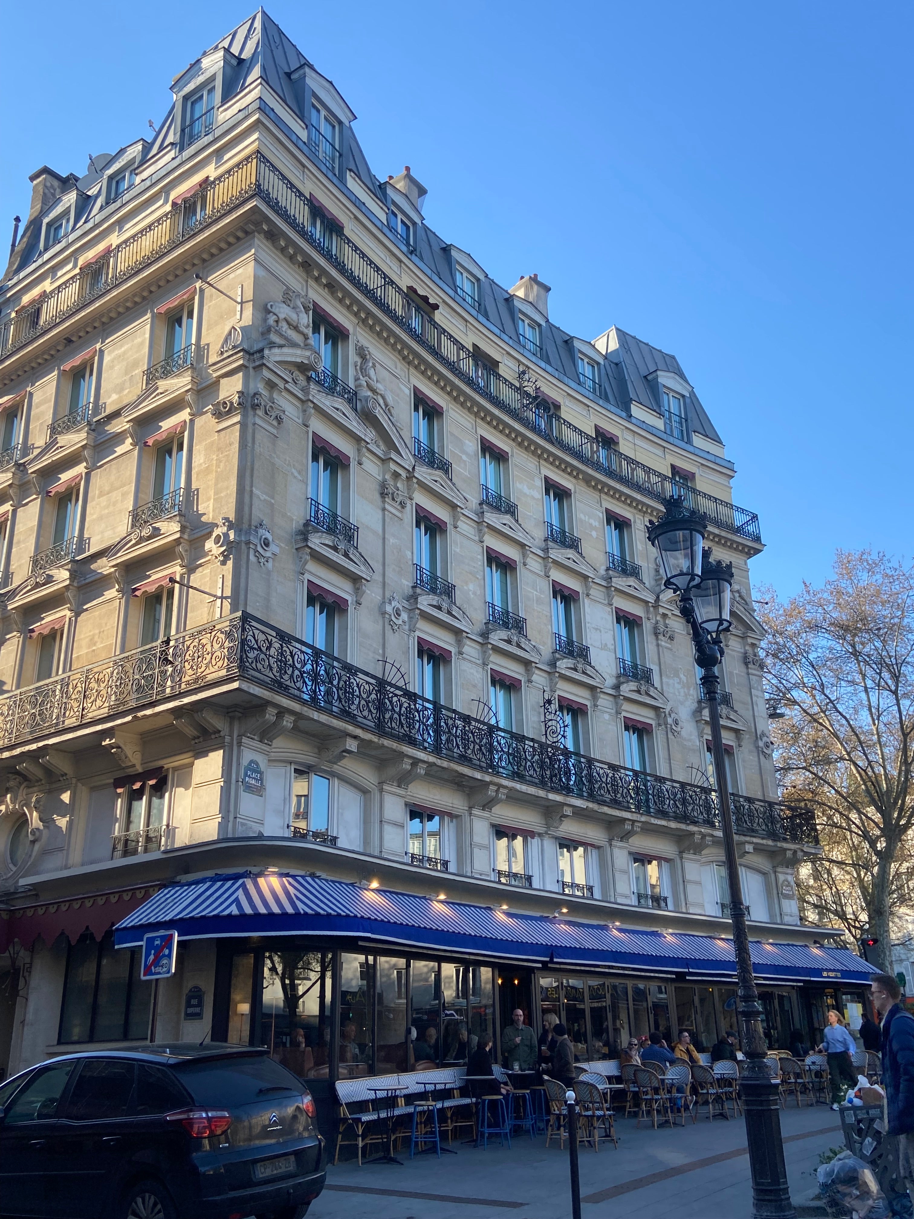 Immeuble haussmannien d’angle rue Duperré à Pigalle Paris 9 avec café en terrasse et architecture typique parisienne
