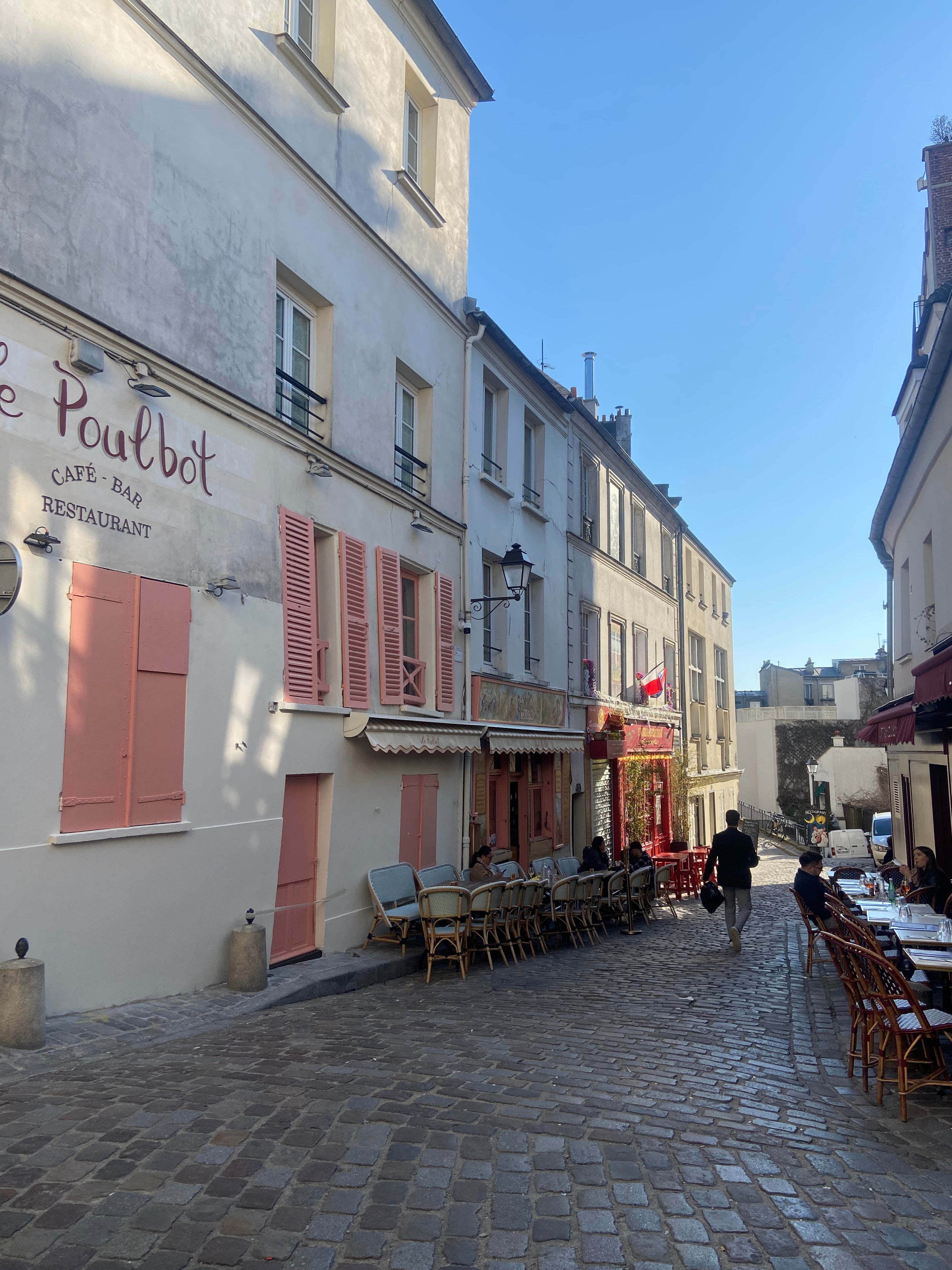 Terrasse de restaurant rue Poulbot à Montmartre Paris avec rue pavée