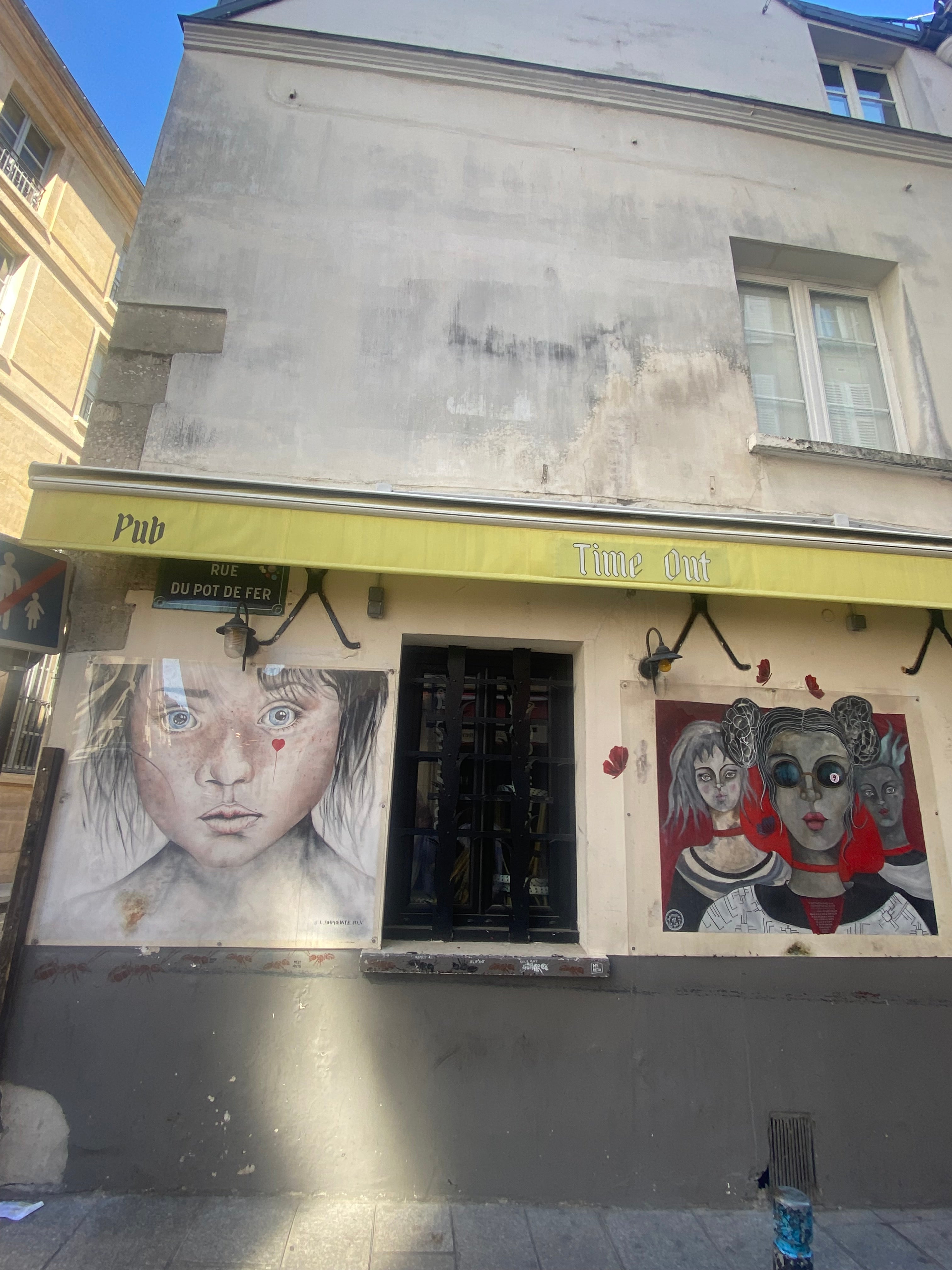 Street art avec portraits peints sur une façade de bâtiment à Paris rue du Pot de Fer